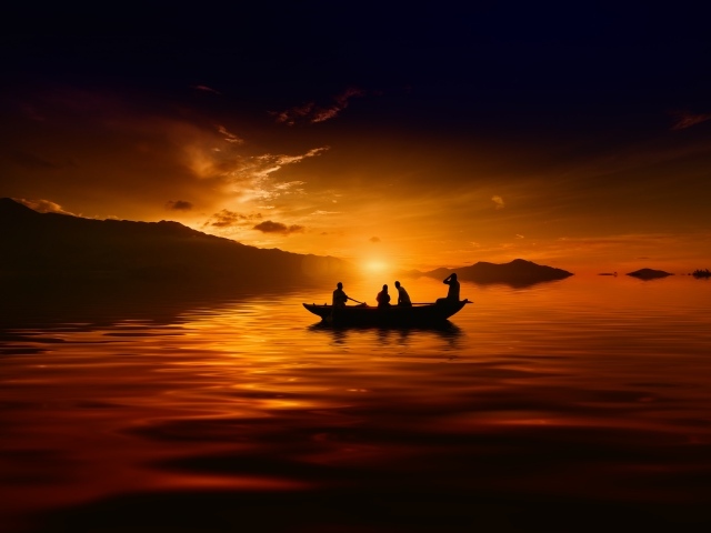 Лодка с людьми на озере на закате