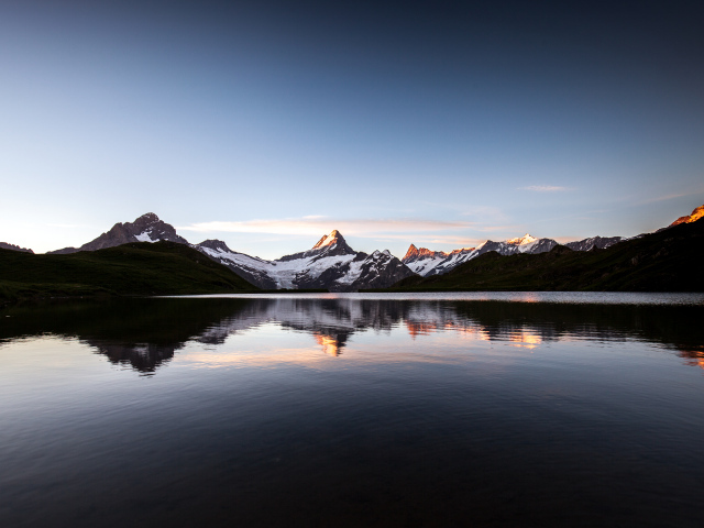 Спокойное горное озеро у заснеженных гор 