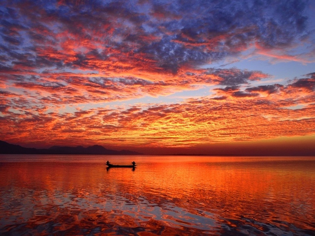 Лодка на воде спокойного озера на закате