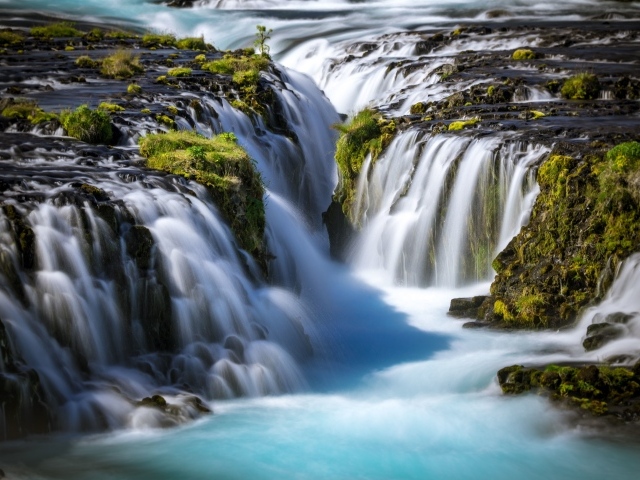 Быстрый водопад стекает по горам, Исландия
