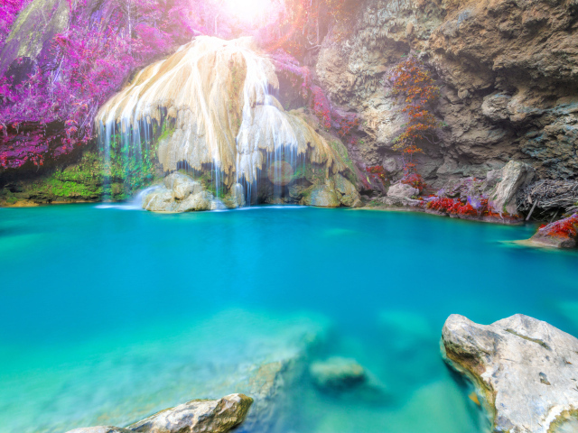 Водопад стекает по скале в голубую воду, Тайланд