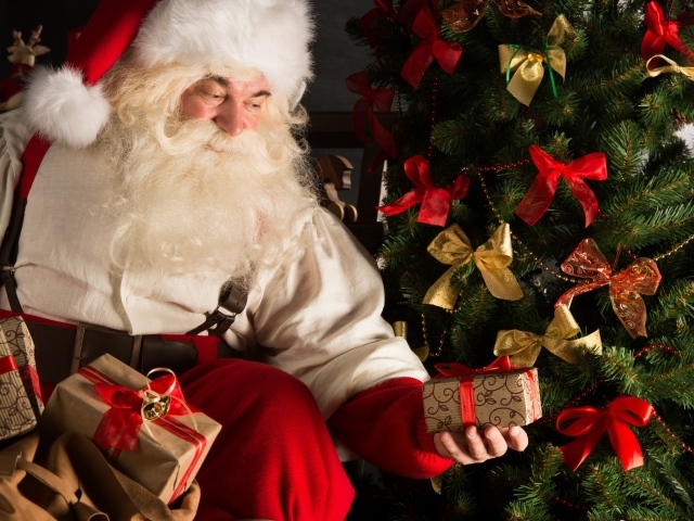 Дед Мороз кладет подарки под елку на новый год 