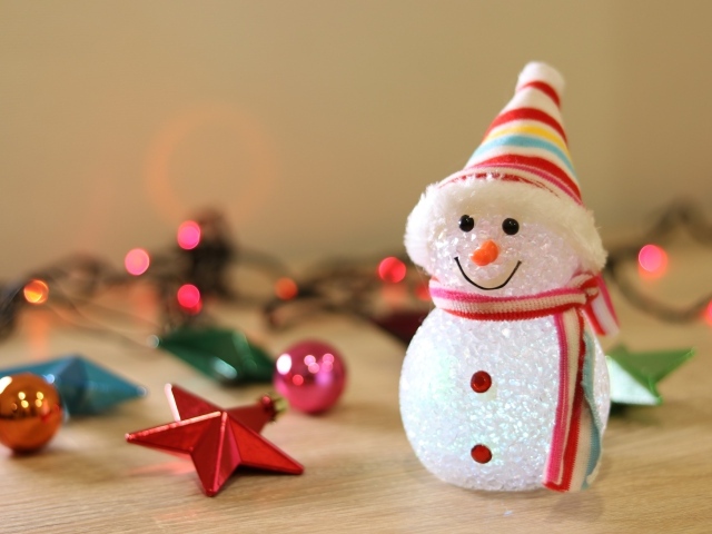 Снеговик с новогодними игрушками на столе
