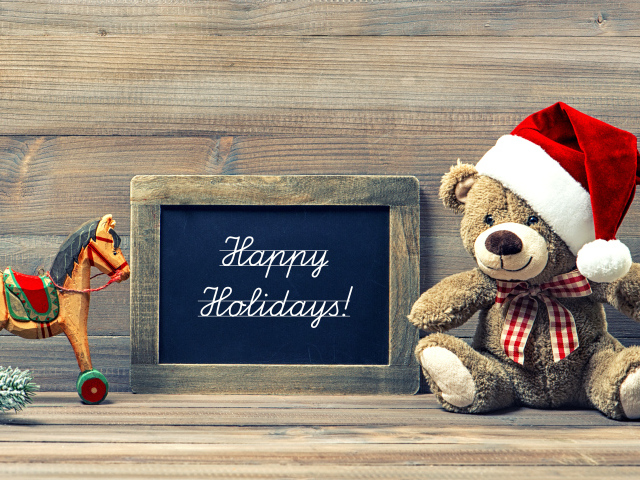 Игрушечный медвежонок Тедди в новогоднем колпаке на деревянном фоне с рамкой