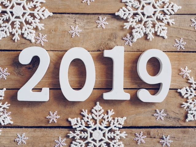 Белые цифры 2019 на деревянном столе с белыми снежинками