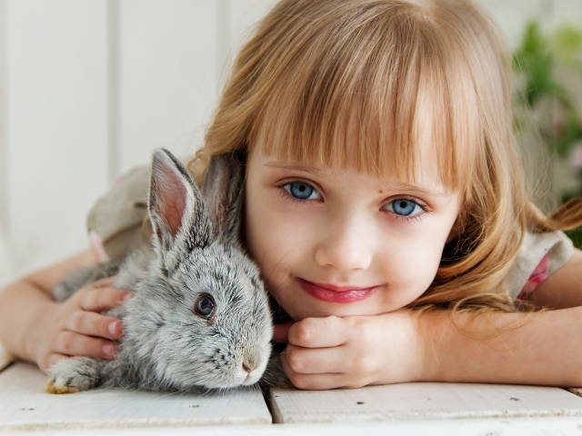 Красивая голубоглазая девочка с серым кроликом