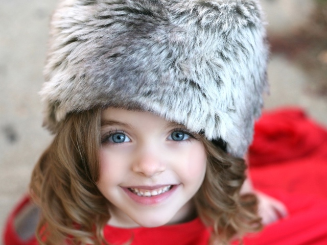 Красивая улыбающаяся девочка в меховой шапке