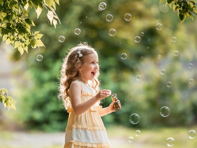 Веселая девочка с мыльными пузырями