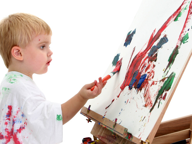 Маленький мальчик рисует красками 