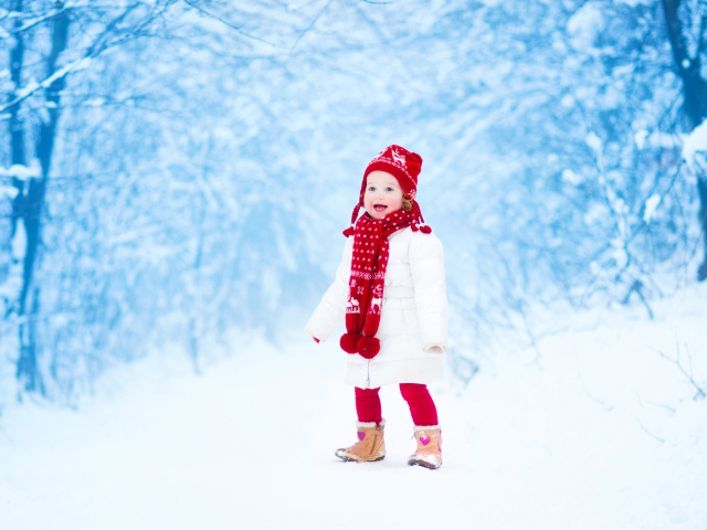 Маленькая веселая девочка в зимнем лесу