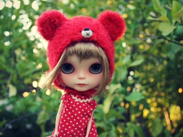 Маленькая кукла с большими глазами в красной шапке