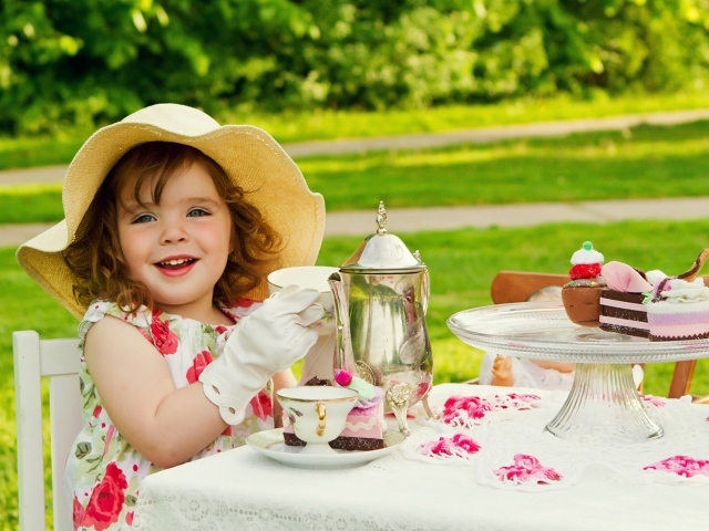 Маленькая девочка пьет чай на природе