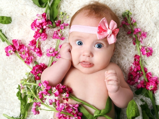 Маленькая девочка с повязкой лежит с розовыми цветами