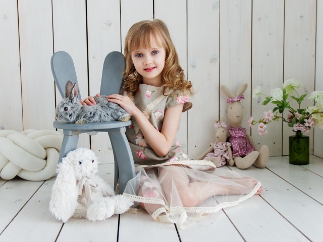 Маленькая девочка с игрушками в комнате сидит на полу