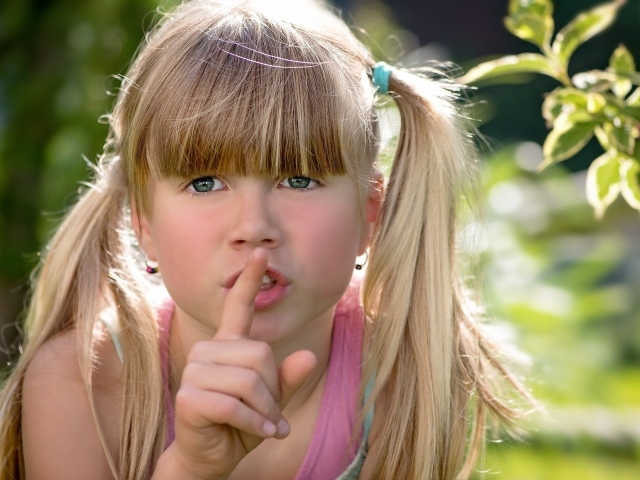 Маленькая зеленоглазая девочка с пальцем у рта 
