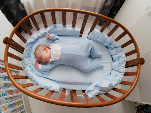 Спящий грудной ребенок в кроватке