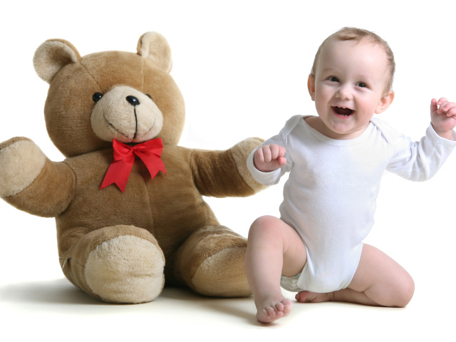 Улыбающийся малыш в большим игрушечным медведем