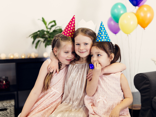 Три маленькие девочки в праздничных колпаках