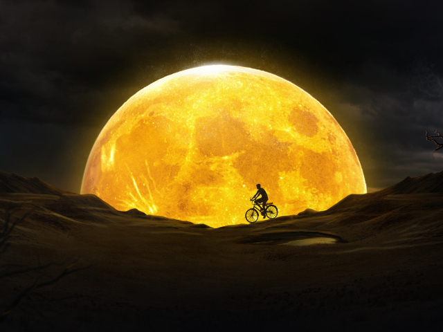 Мужчина на велосипеде едет на фоне большой оранжевой луны 