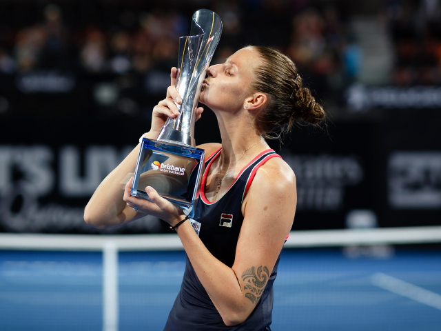 Чешская теннисистка Каролина Плишкова целует кубок на корте