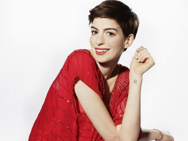 Актриса Энн Хэтэуэй в красном наряде с короткой стрижкой