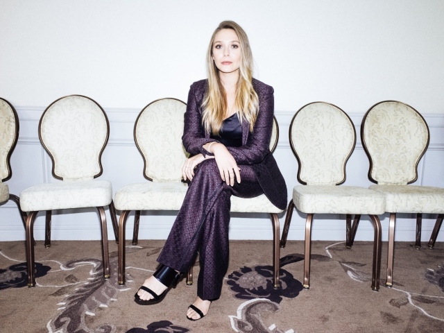 Красивая актриса Элизабет Олсен  в костюме сидит на стуле
