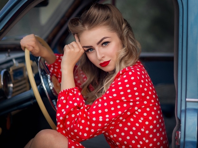 Голубоглазая ретро девушка за рулем автомобиля 