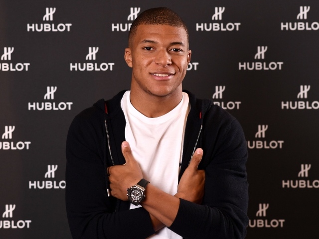 Футболист Килиан Мбаппе в костюме с часами на руке