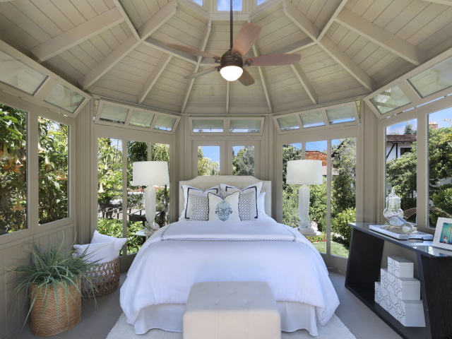 Большая спальная комната с окнами и белой кроватью 