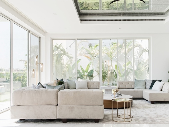 Большая гостиная комната с диваном и большими окнами