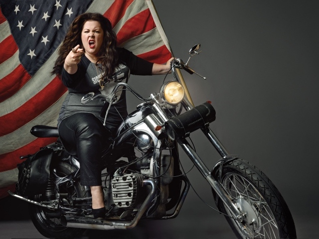 Популярная актриса Мелисса Маккарти на мотоцикле с флагом