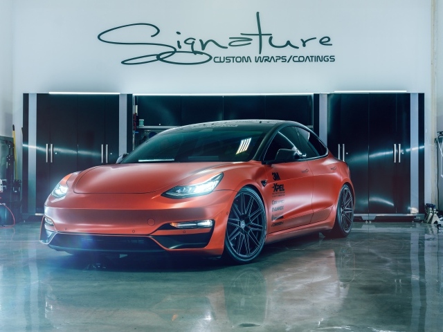 Красный автомобиль Tesla Model 3 в гараже