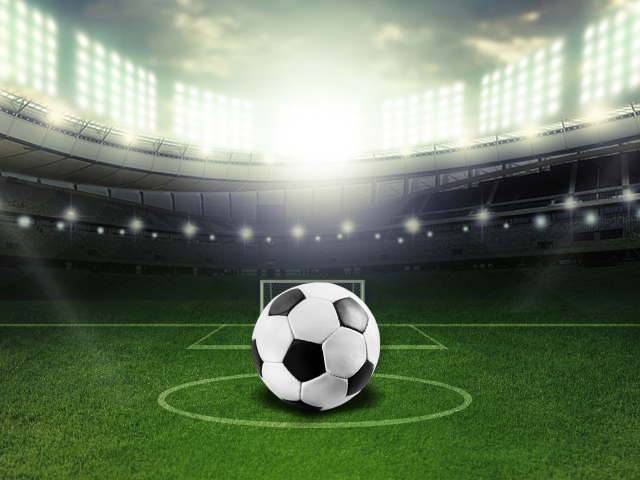 Футбольный мяч лежит на футбольном поле на стадионе