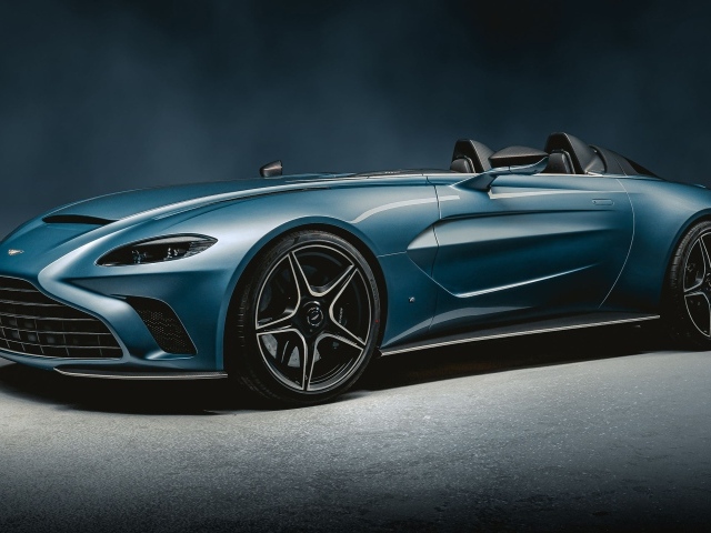 Синий автомобиль Aston Martin V12 Speedster 2020 года на сером фоне