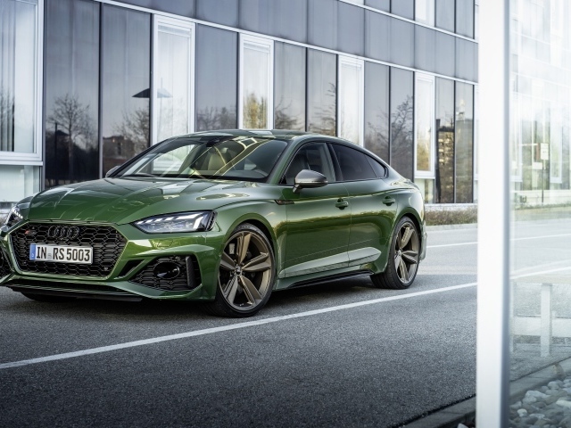 Зеленый автомобиль Audi RS 5 Sportback 2020 года у здания 