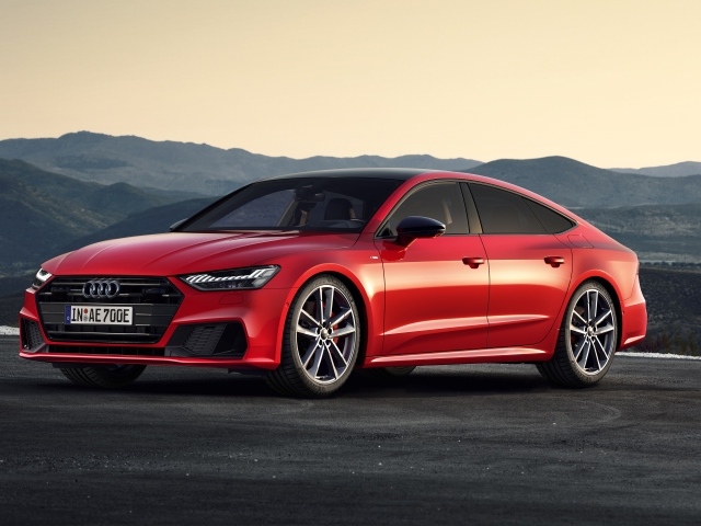 Красный автомобиль Audi A7 Sportback 55 TFSI E Quattro S Line 2019 года в горах