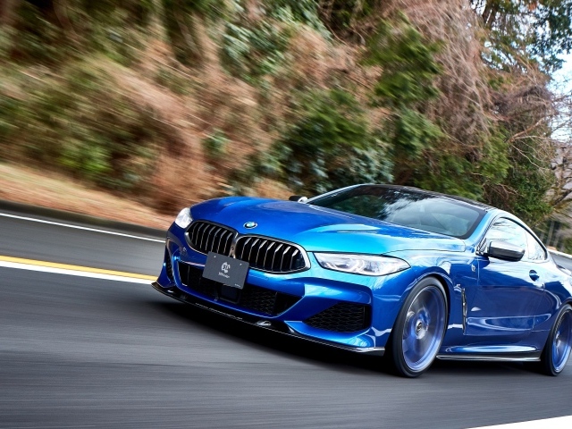 Синий автомобиль  BMW M850i XDrive Coupe 2020 года на дороге