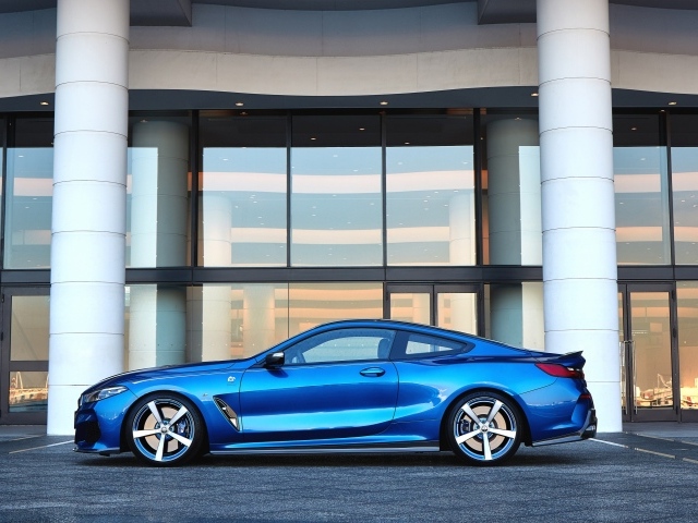 Голубой автомобиль BMW M850i XDrive Coupe 2020 года у здания 