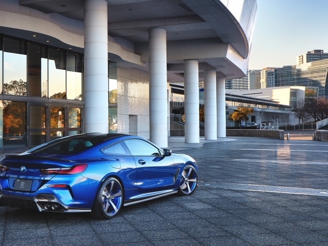 Синий автомобиль BMW M850i XDrive Coupe 2020 года у здания вид сзади