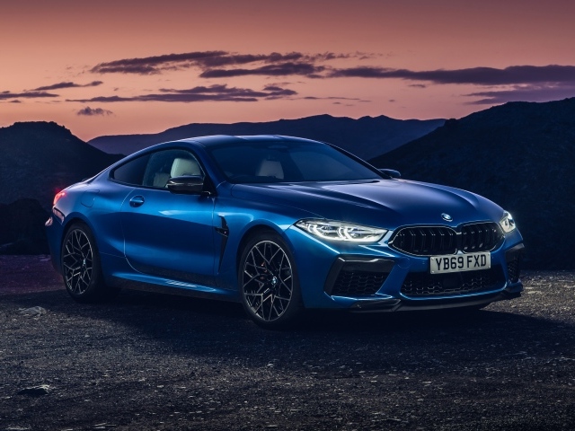 Синий автомобиль BMW M8, 2019 года на фоне гор