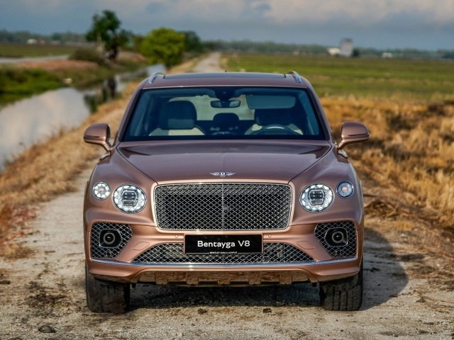 Коричневый автомобиль Bentley Bentayga V8 2020 года у реки
