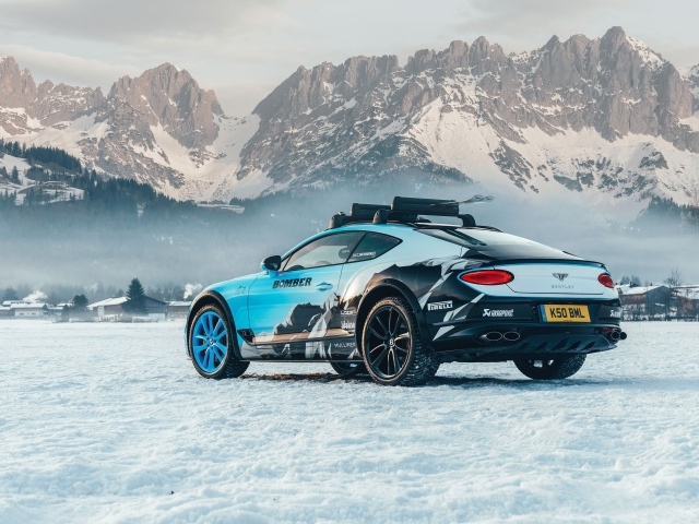 Автомобиль bentley continental gt, 2020 года на фоне заснеженных гор 