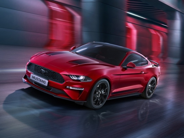 Красный автомобиль Ford Mustang едет по городу