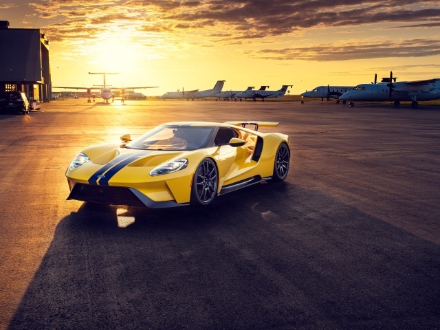 Желтый спортивный автомобиль Ford GT на закате