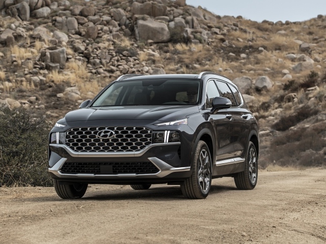 Черный автомобиль  Hyundai Santa Fe Hybrid, 2021 года у камней