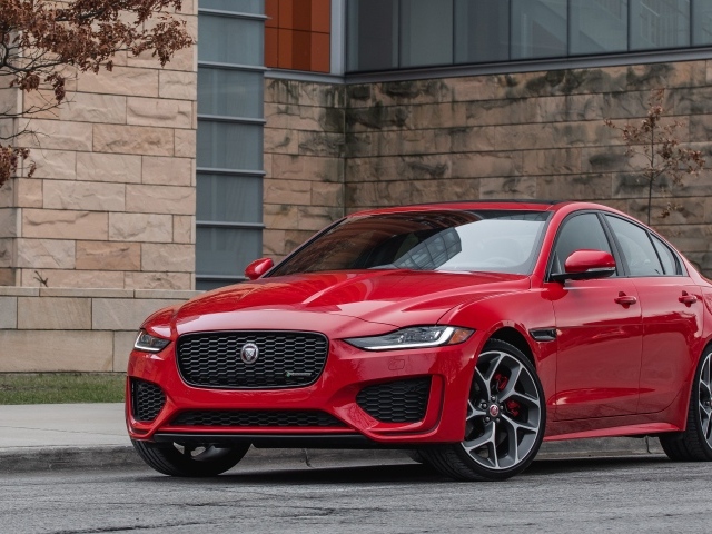 Красный автомобиль Jaguar XE P300 R-Dynamic, 2020 года у здания