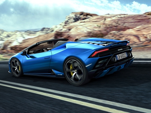 Быстрый синий автомобиль Lamborghini Huracan EVO RWD Spyder 2020 года на фоне скал 