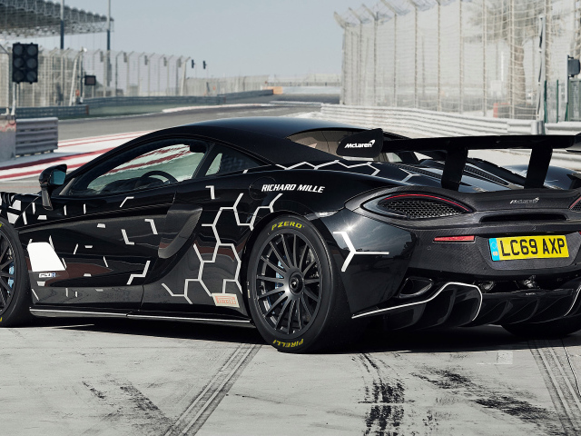 Черный спортивный автомобиль McLaren 620R на автодроме