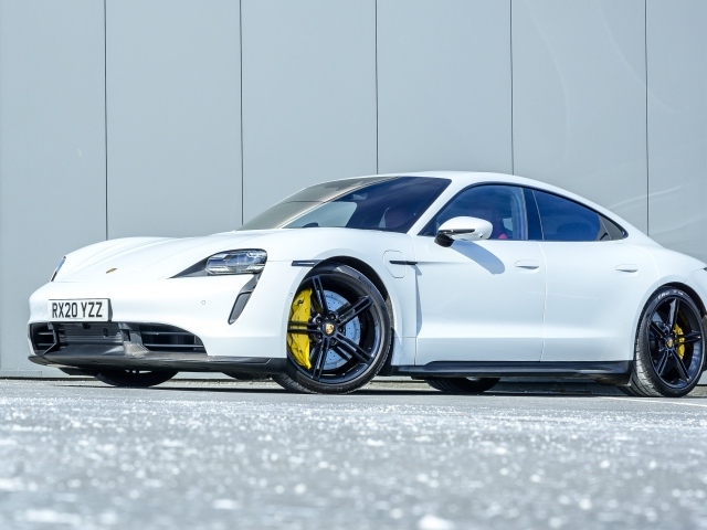 Белый автомобиль Porsche Taycan Turbo S 2020 года в лучах солнца 