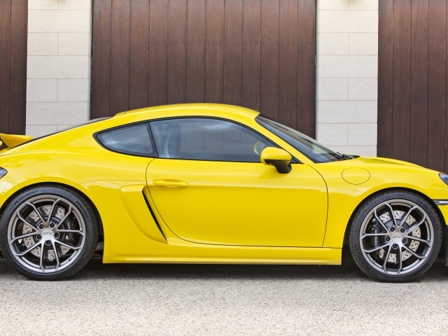 Желтый автомобиль Porsche 718 Cayman GT4 2020 года вид сбоку